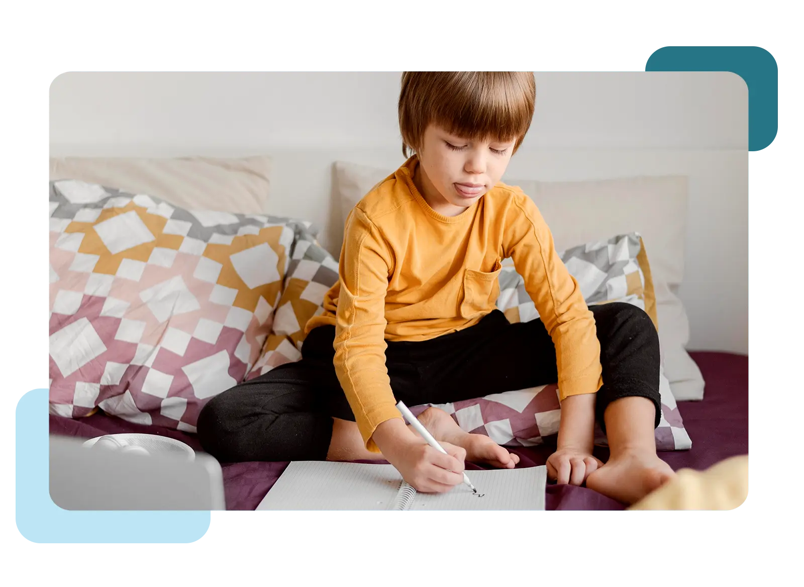 Young man writing in a journal while lying in bed.