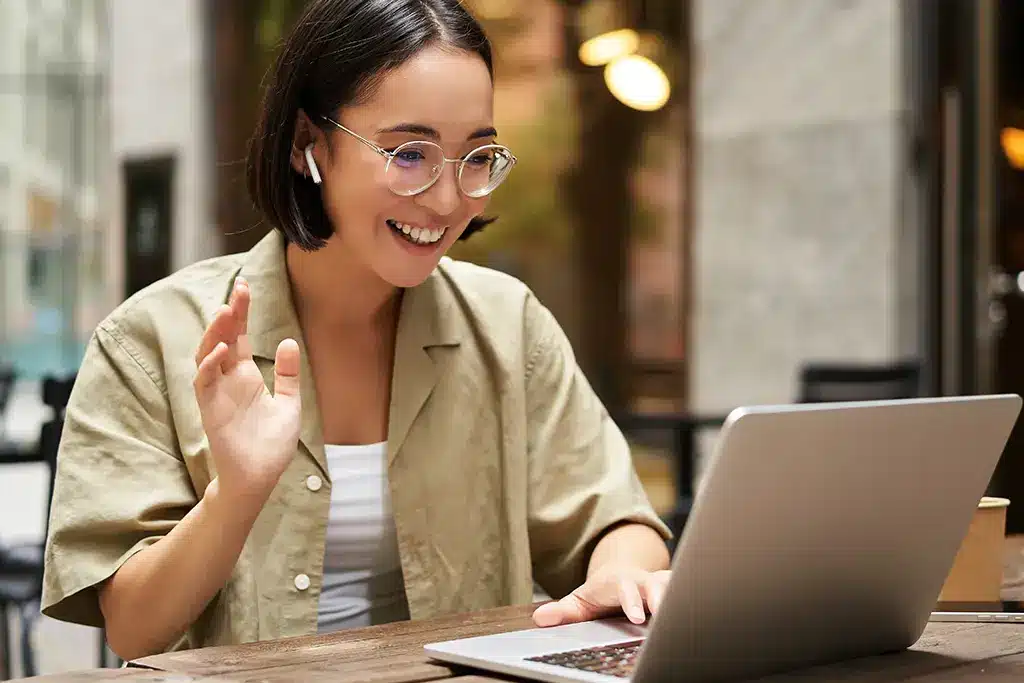 Student on a video call, waving hello.