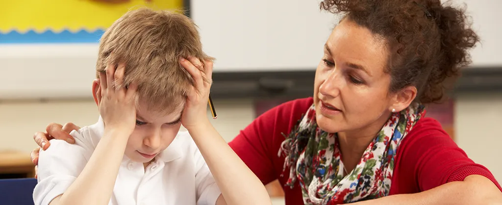 Teacher encouraging a student who is disengaged in class with supportive guidance and attention