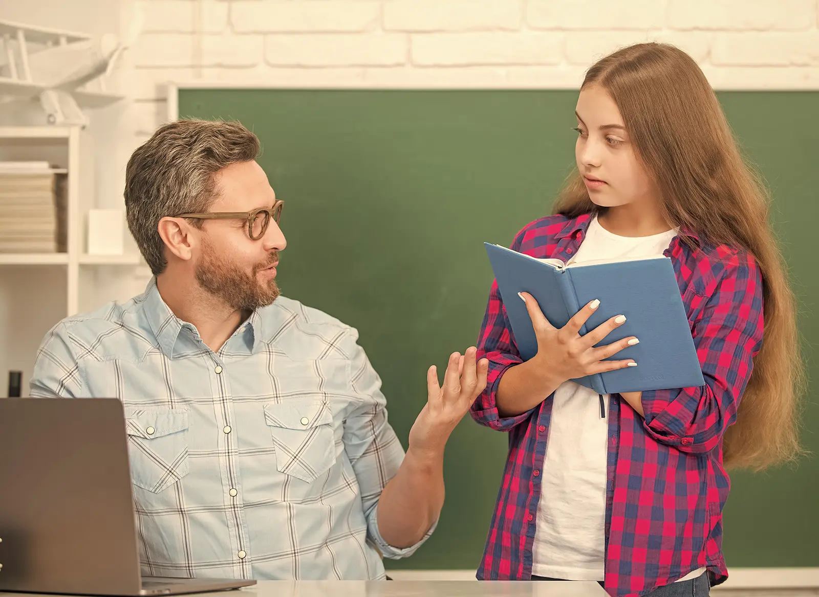 Teacher encouraging a student who is disengaged in class with supportive guidance and attention